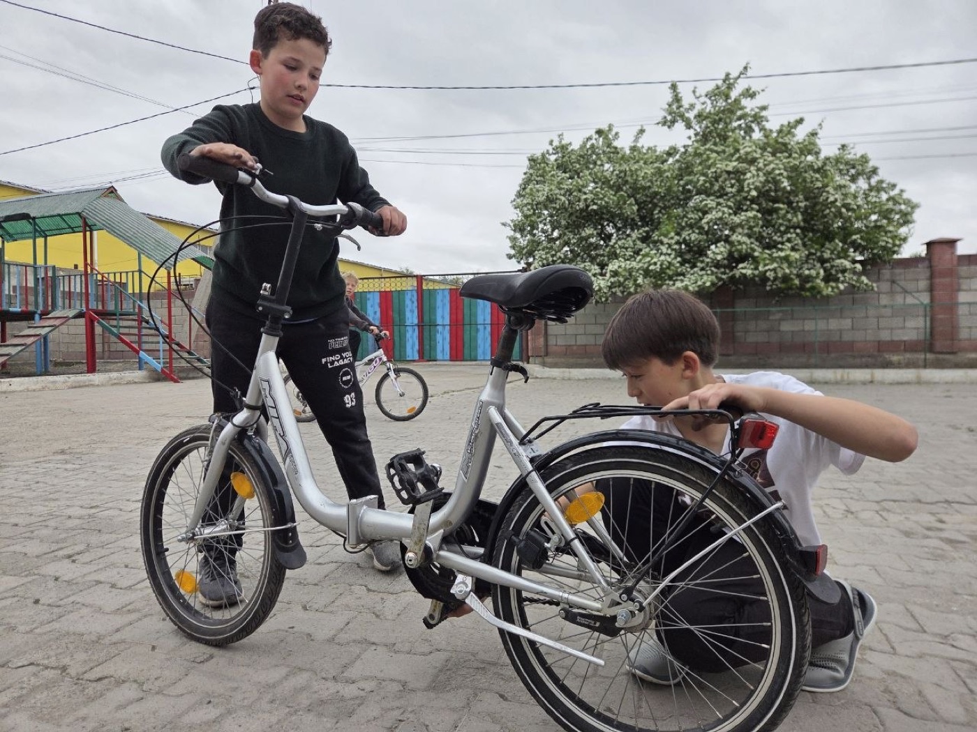 Zwei Jungen reparieren gemeinsam ein Fahrrad